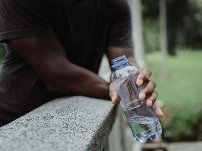 Detail of hands holding a water bottle during rest.